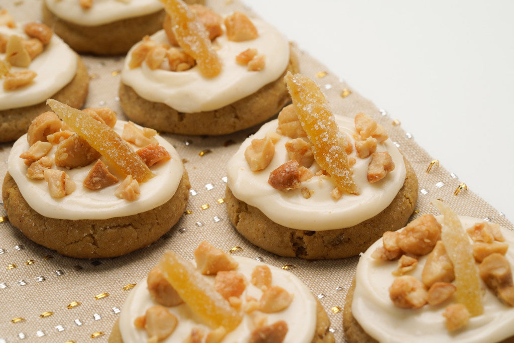 Cookies with white frosting and candied ginger on a decorative surface. Whiskey Gingers cookie, winning cookie of the 2019 Star Tribune Holiday Cookie Contest.